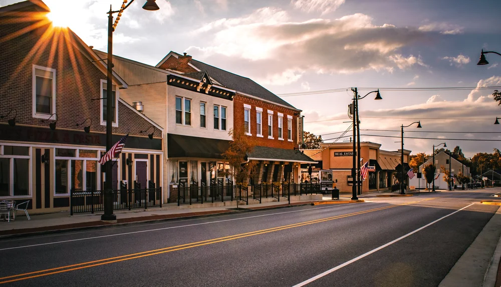 An Oakland County main street at sunset, American flags on the lampposts